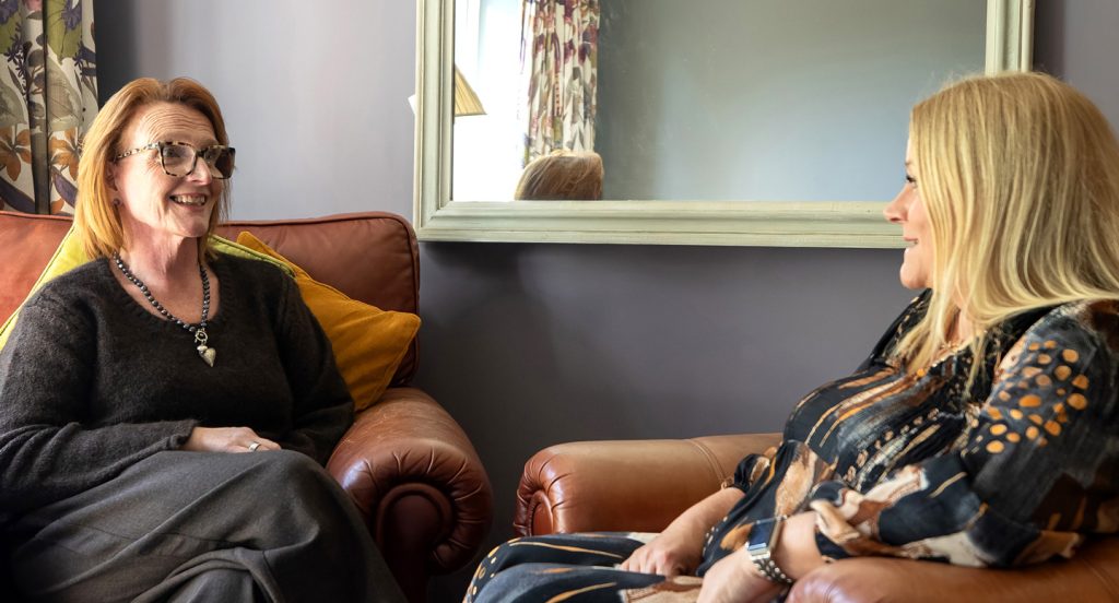 Two women chatting in a comfortable environment.